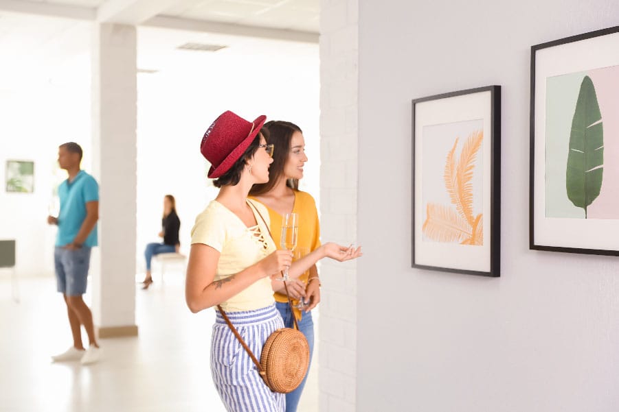 Amigos viendo cuadros en un galería de arte